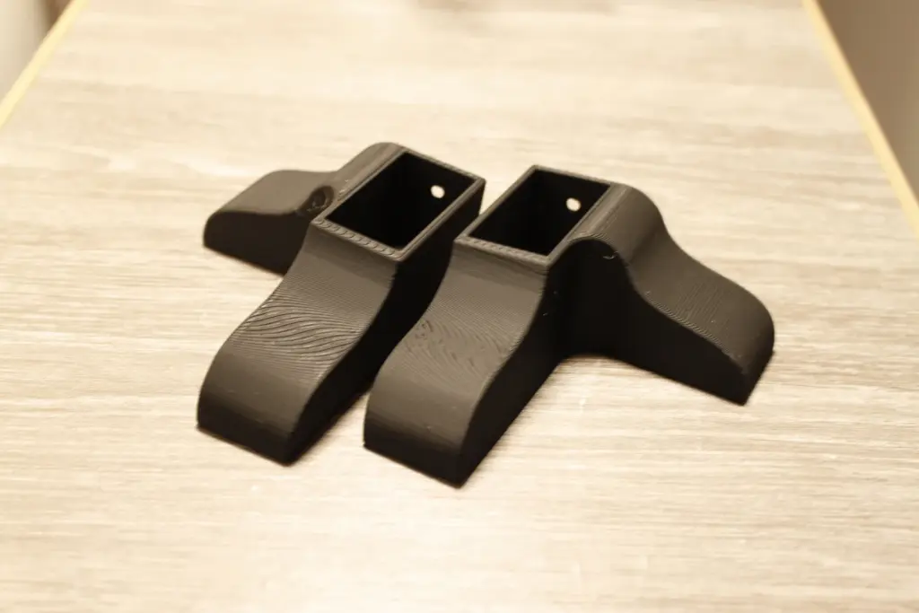 Schwarze Kunststoffhalter auf Holztisch.