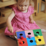 Kind spielt mit buntem Montessori-Spielzeug.