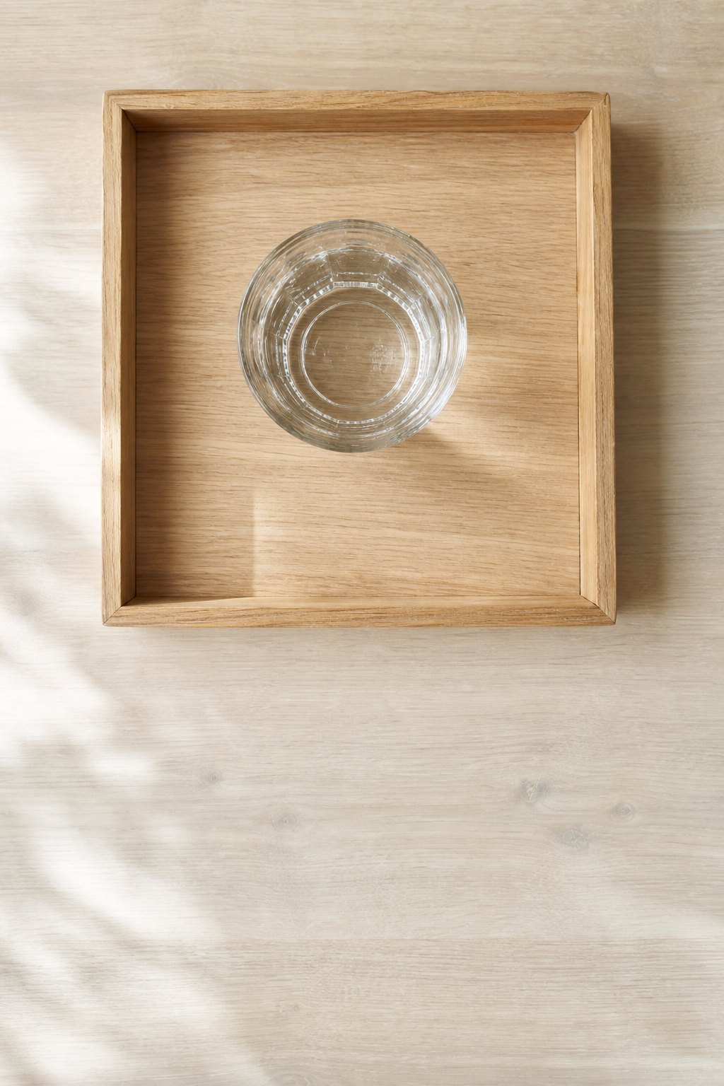 Tablett mit einem Glas Wasser, in dem Kastanien schwimmen oder auf dem Boden liegen