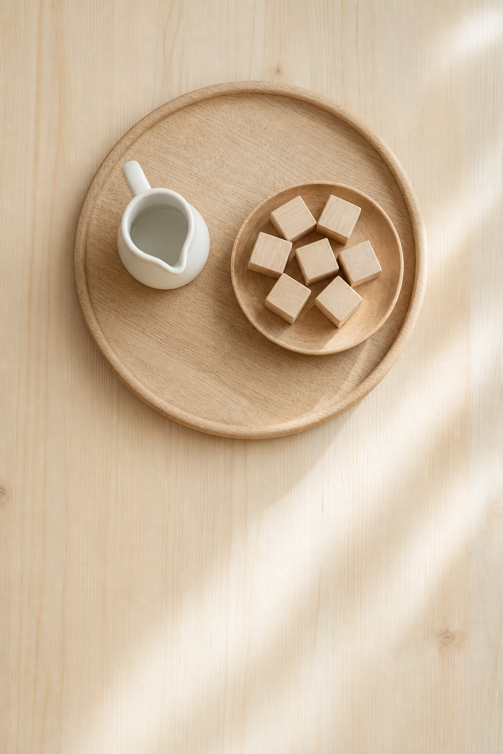 Tablett mit kleinem Krug und einer Holzschale voller unlackierter Holzteile