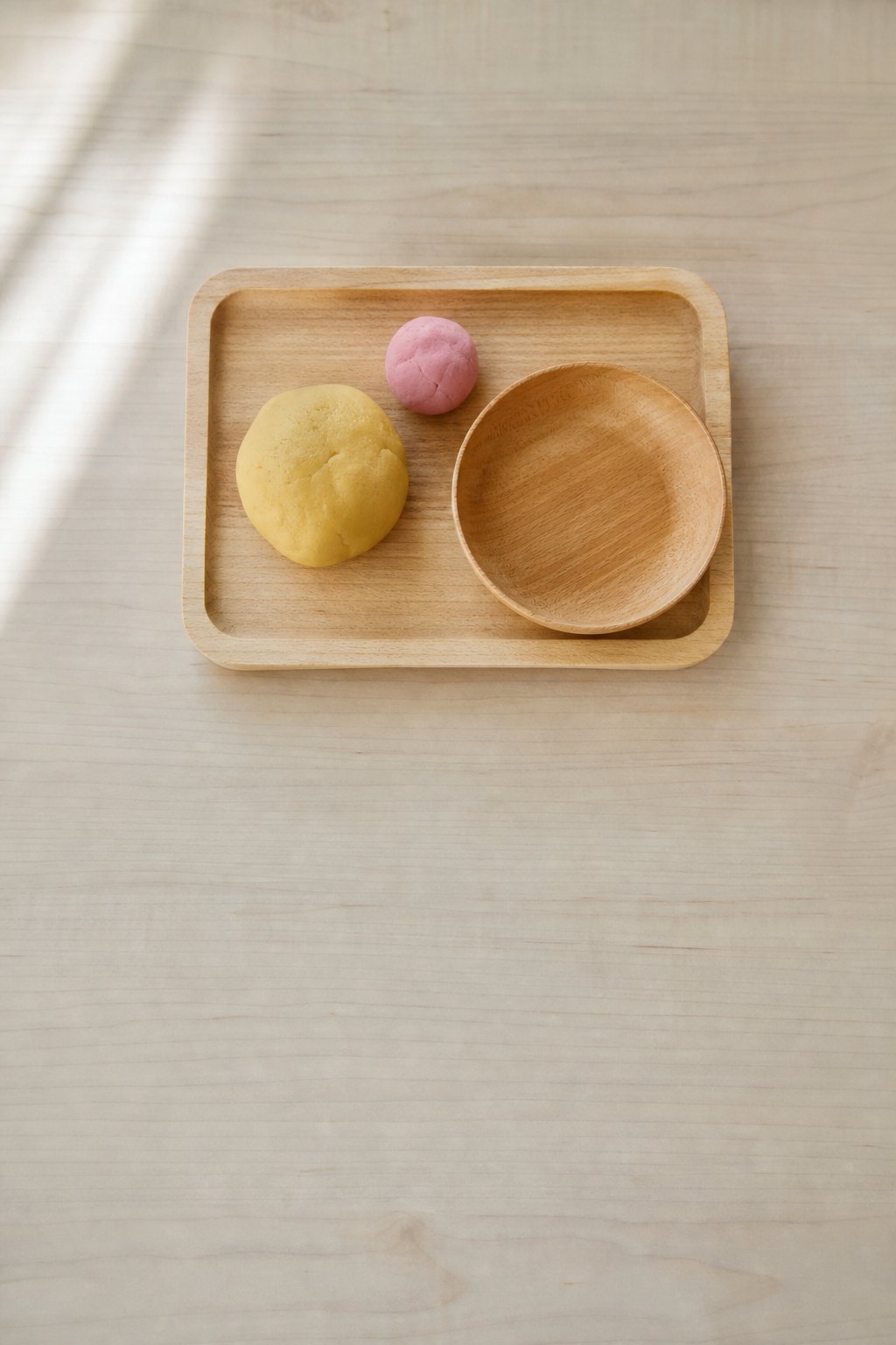Tablett mit einer gelben und einer rosa Kugel selbstgemachter Knete