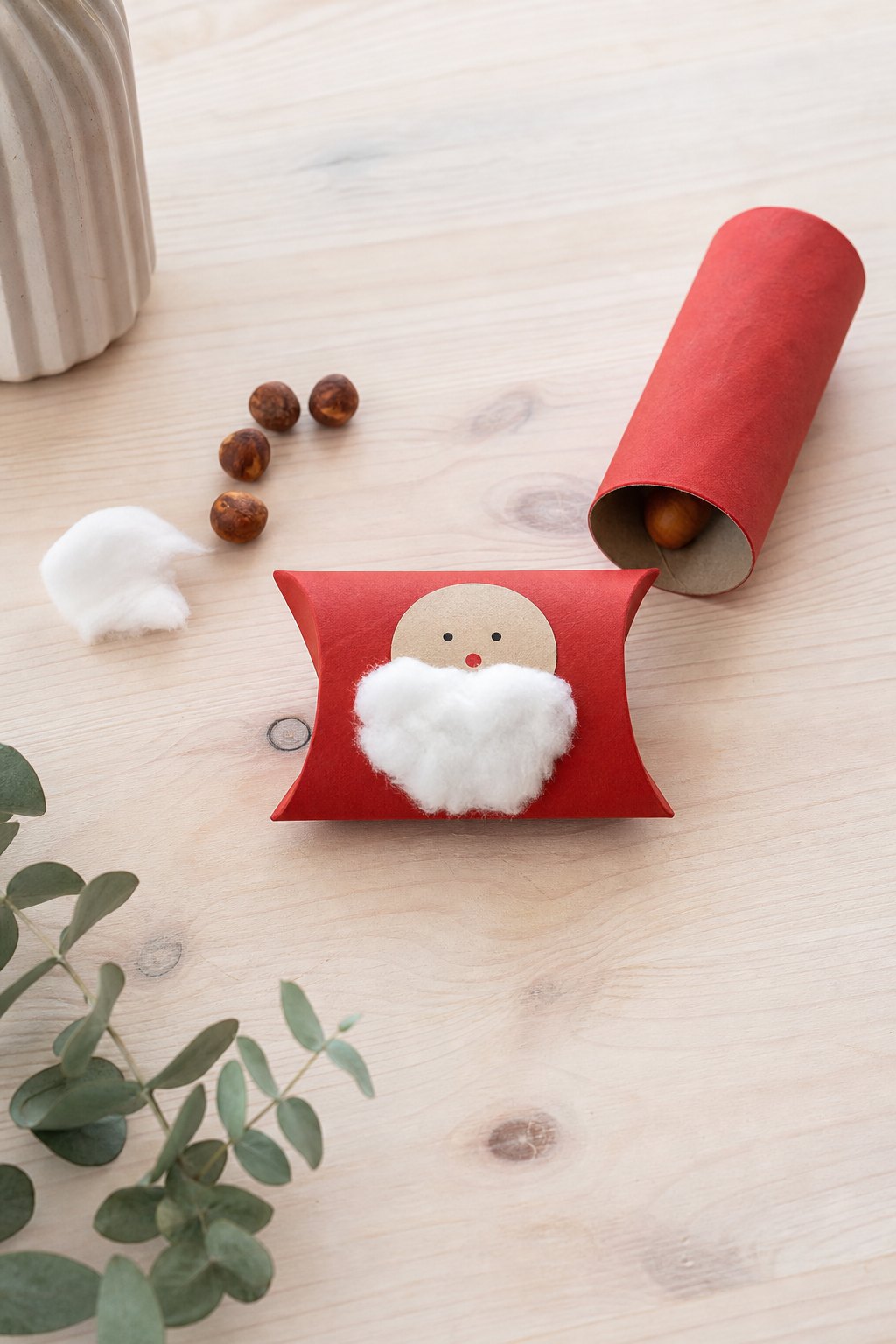 Die Nikolaus-Schachtel aus der Klorolle — Eine kleine kissenfoermige Schachtel aus einer rot bemalten Klopapierrolle liegt au